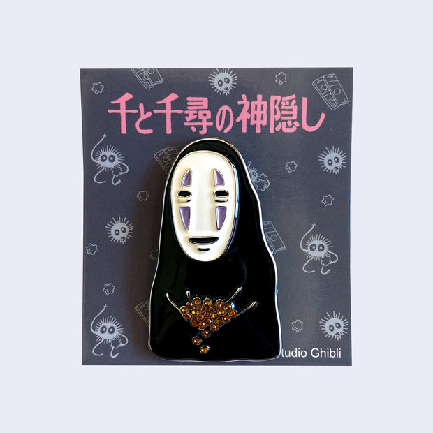 Brooch of No Face in slight chibi form, holding a pile of glittering orange gems.