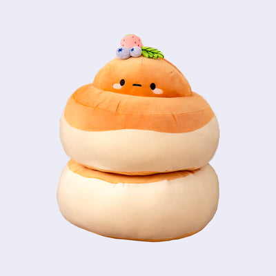 Fluffy looking stack of pancakes, in plushie form. At the top is the head of a potato character with a cute expression and berries atop its head.