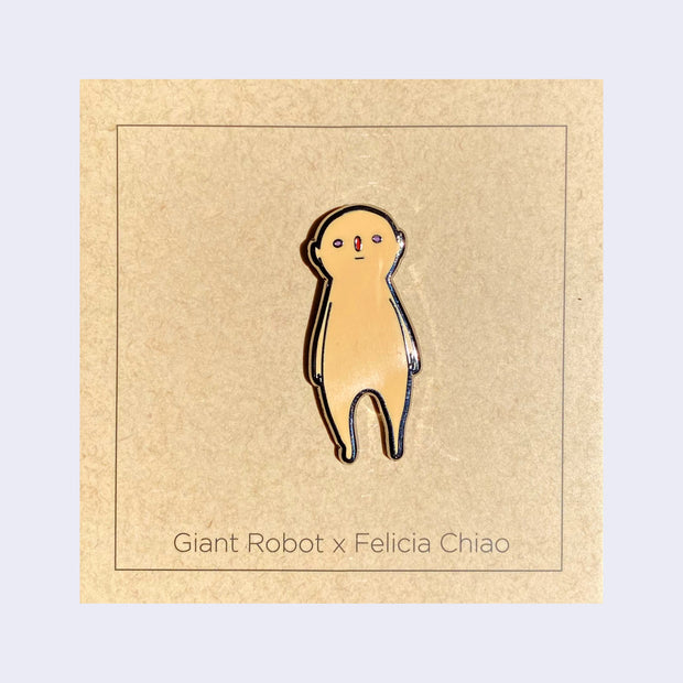 Enamel pin of a light tan, semi anthropomorphic character standing with its arms at its side and looking straight on.