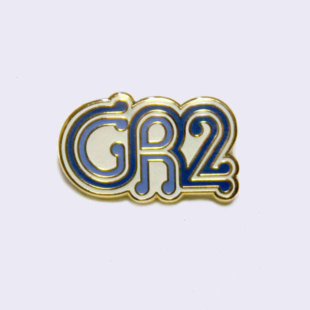 Enamel pin of "GR2" written stylistically in blue with gold and white outlined accents.