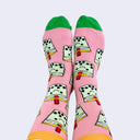 Front view of a model's feet wearing chubby cartoon boba socks. The sock is mainly bubblegum pink and complements the smiling mint colored bobas.