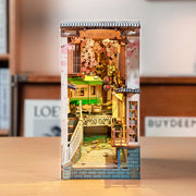 Fully assembled book end model, a Japanese alley way with a body of water, a tram going through and cherry blossom trees.