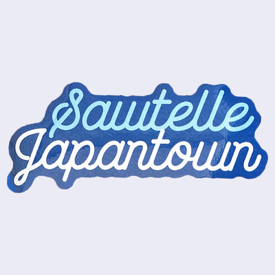 Blue cut out sticker with "Sawtelle Japantown" written in light blue and white, cursive font. "Sawtelle" is stacked above "Japantown."