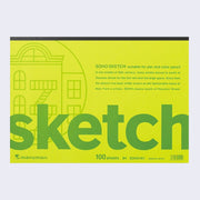 Green flat, horizontal sketch pad that is glue bound at the top. Descriptive writing is written next to an illustration of a simplistic building with a fire escape. Sketch is written in large font across the top.