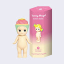 Vinyl figure of a Kewpie baby standing nude with a pink frosting vanilla cupcake hat atop its head. It stands next to a pink display box that reads "Sonny Angel Sweets Series"
