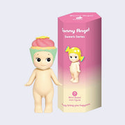 Vinyl figure of a Kewpie baby standing nude with a pink frosting vanilla cupcake hat atop its head. It stands next to a pink display box that reads "Sonny Angel Sweets Series"