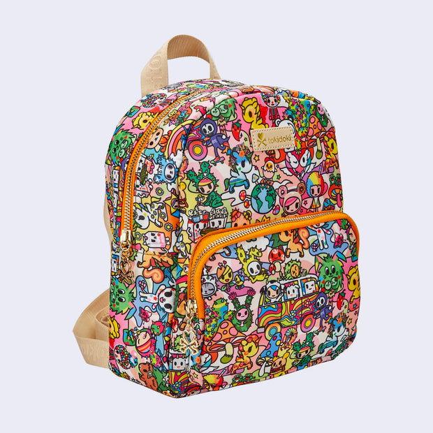 Side angle of small backpack with an additional compartment in the front bottom, lined by orange fabric and a gold zipper. A tan "tokidoki" name plate is in the center and a tan loop of fabric for hanging appears at the top. Backpack is covered completely in a very busy colorful pattern of various Tokidoki characters accompanied by elements reminiscent of 70's imagery, such as rainbows, mushrooms, VW Buses and flowers.
