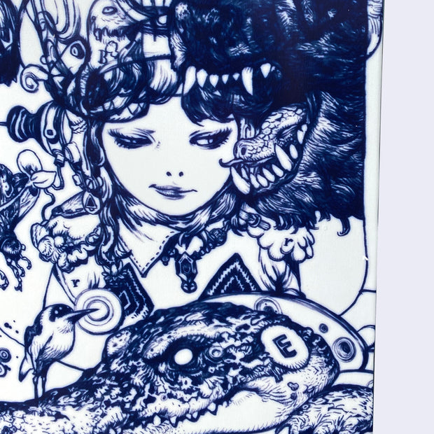 Close up of white skateboard deck with intricate blue line art illustration. Close up displays a younger girl, smirking and looking off to the side at an open growling bear's mouth. She wears a gem necklace and has an intricate helmet and headphones. Below her is an alligator with a metal collar and the letter "E" on its head.