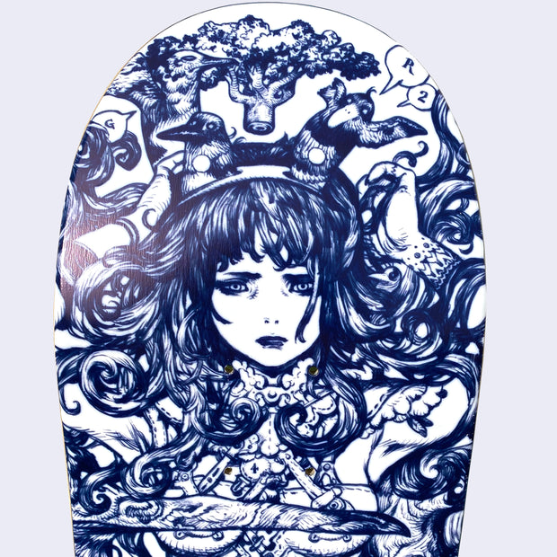Close up of white skateboard deck with intricate blue line art illustration. Close up displays a woman with an anguished expression, with splayed out hair and two birds coming out of a headband. Her arms are raised to her head and her body is tattooed.