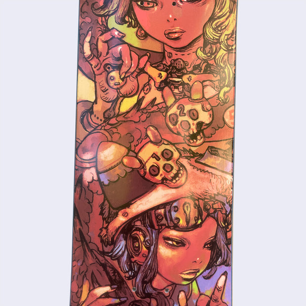 Close up of two intricately illustrated women, one holds a bear trinket in her hand and has skulls near her body, the other woman wears an intricate helmet and looks to the side indifferently.