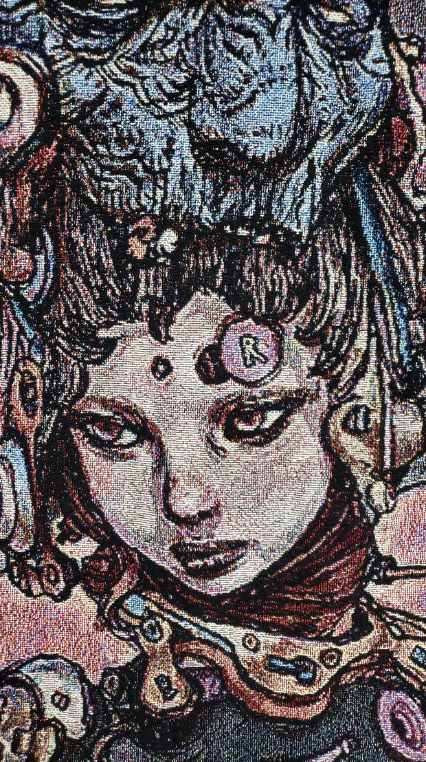 Close up of tapestry, displaying a woman with a stoic expression and mechanical parts coming from her body.