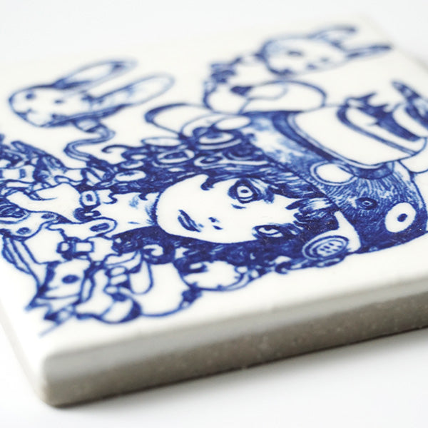 Close up of white ceramic tile with dark blue line art illustration of a woman with many mechanical parts and wires coming out from her.
