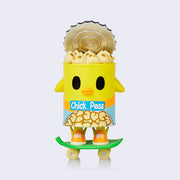 Vinyl figure of a can of chickpeas, styled like a yellow chick riding a skateboard. Its lid is partially open, revealing many chickpeas that have faces of little chicks.
