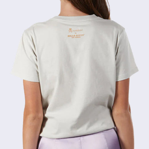 Back view of a light gray, beige-ish fitted shirt, with a tokidoki x Hello Kitty and Friends logo along the top center.