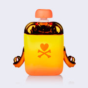 Back view of a vinyl figure of an apple sauce pack, sunset yellow and orange with orange metallic elements. On its back is the tokidoki logo, a heart over a pair of crossed bones.