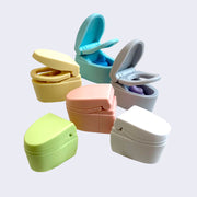 6 differently colored toilet shaped erasers, some with the lid lifted up to reveal a swirled poo inside. Colors include: yellow, pink, green, white, gray and blue.