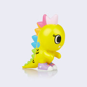 Vinyl "Manimon" figure. Small yellow baby kaiju character with rainbow spikes, wearing lavender sneakers.