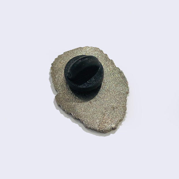 Back of an enamel pin with a rubber backing.